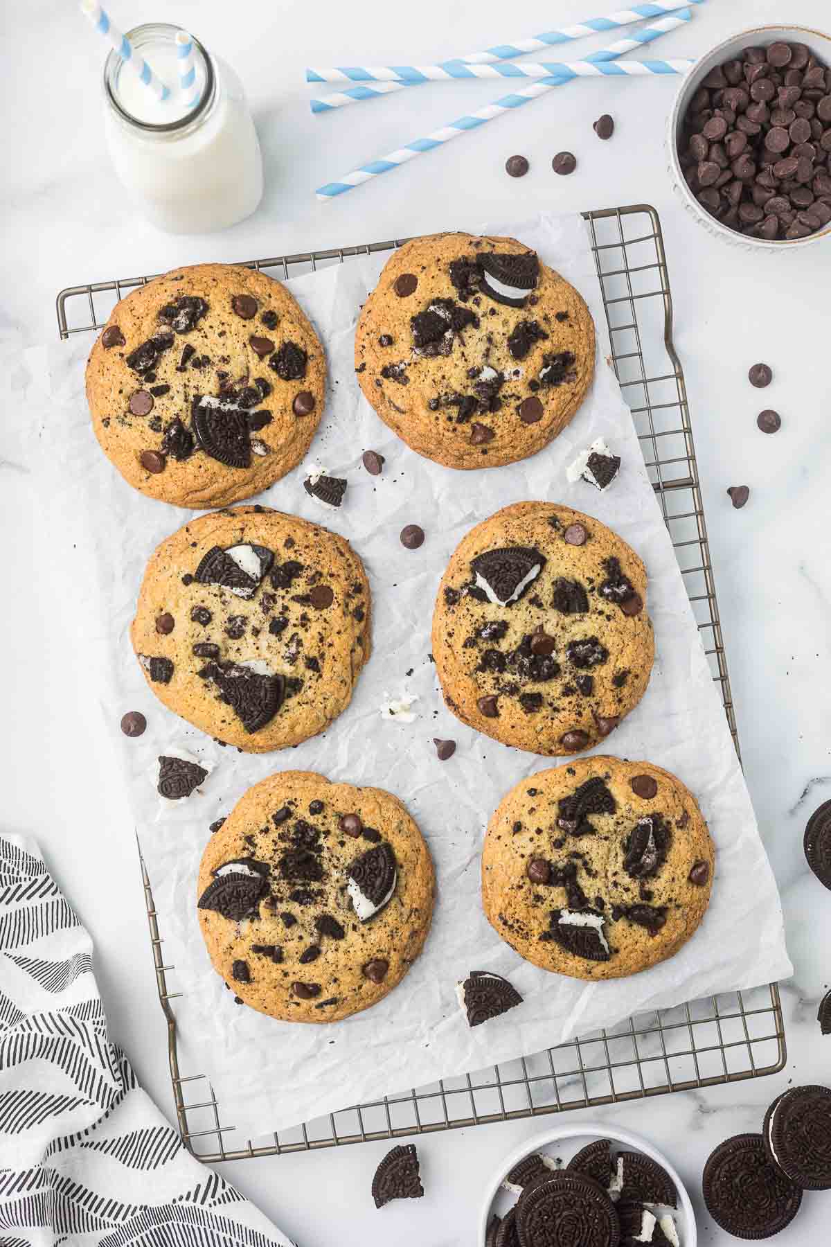 Chocolate Chip Oreo Cookies on a cooling rack with milk and extra Oreo cookies.