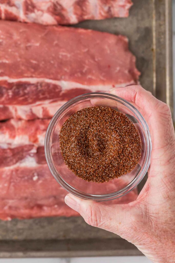 BBQ seasoning in a glass bowl before adding the pork ribs.