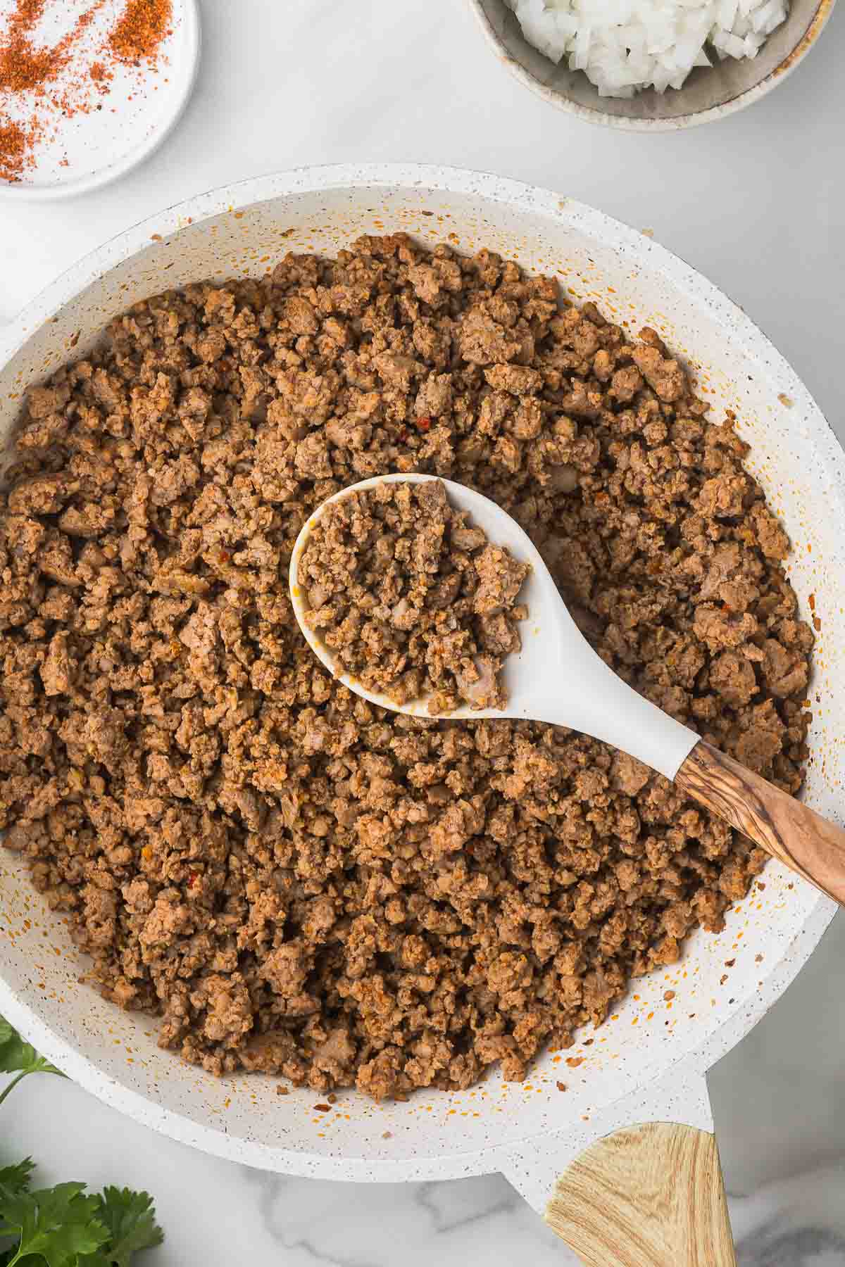 Ground pork with bbq seasoning after it has cooked for 5 minutes.