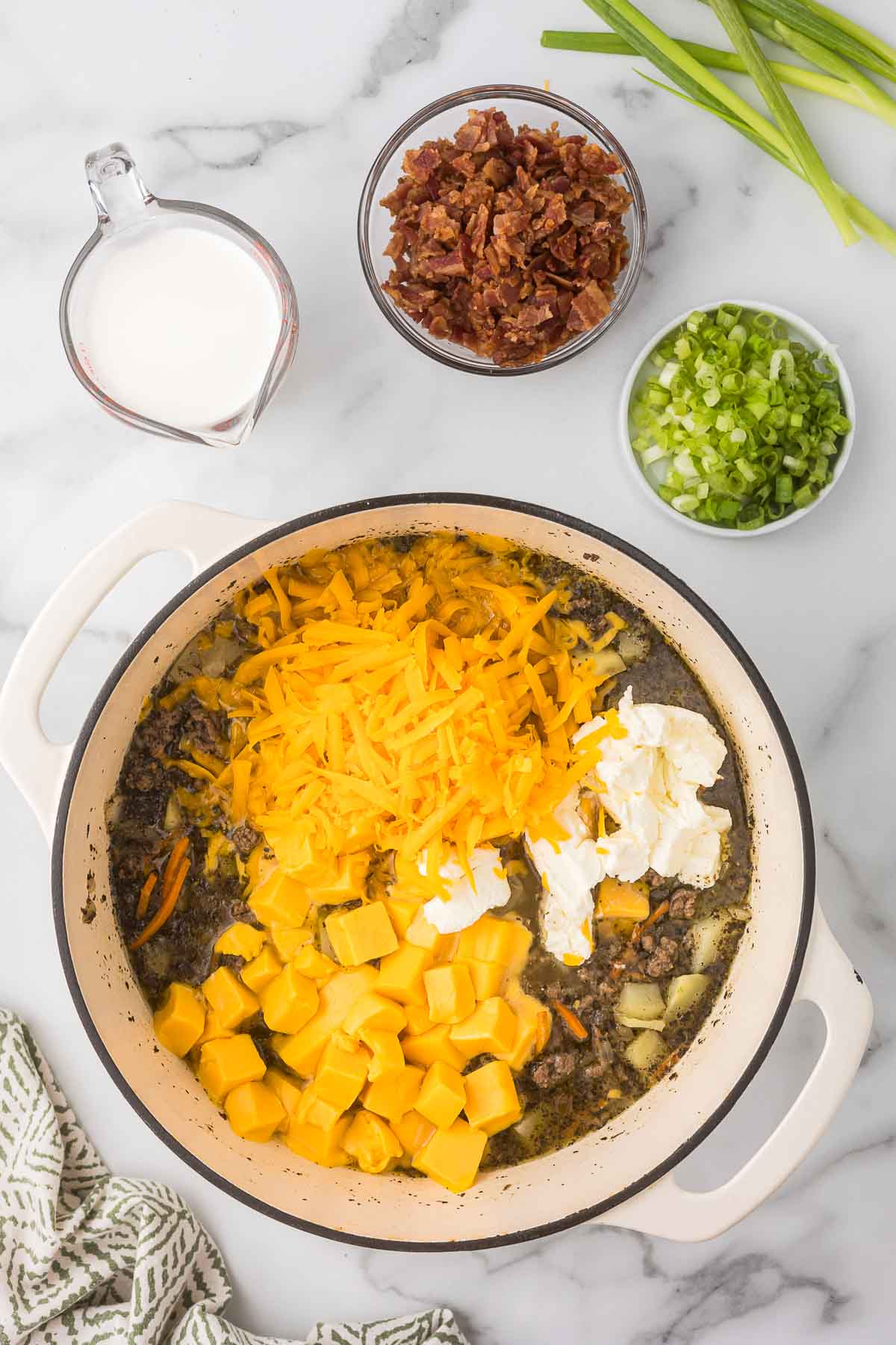 All the ingredients in a dutch oven to make cheeseburger soup before the cheese has melted.