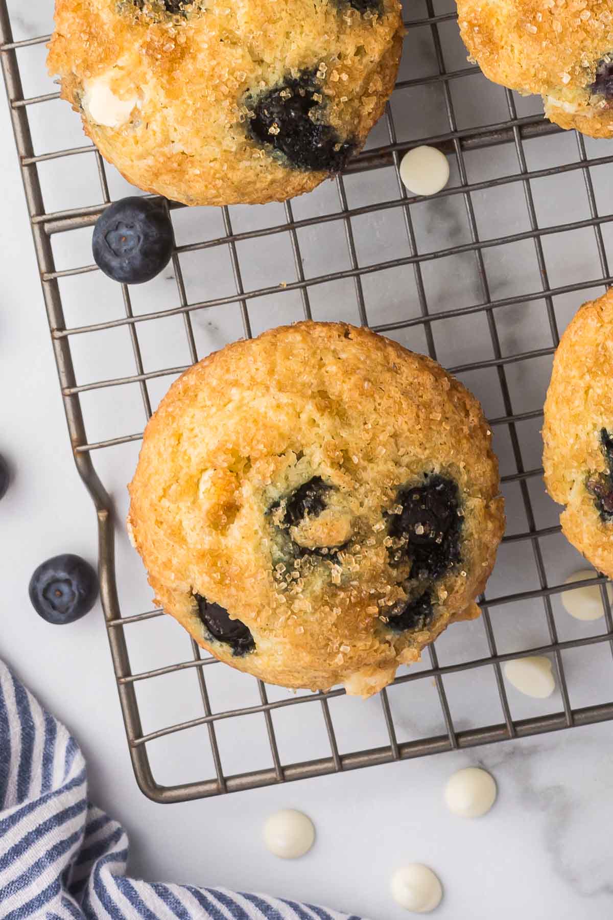 Blueberry white chocolate muffins on a cooling rack.