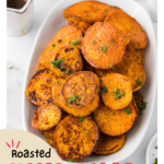 A flipped image of roasted sweet potato slices on a baking sheet. The golden brown slices are arranged with crispy, caramelized edges facing upward. The light seasoning adds texture to the vibrant orange sweet potatoes, making them look appetizing and ready to serve as a nutritious side dish.