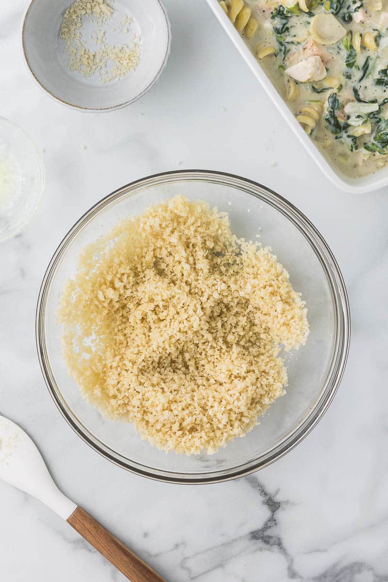 Bread crumbs in a bowl with butter mixed in.