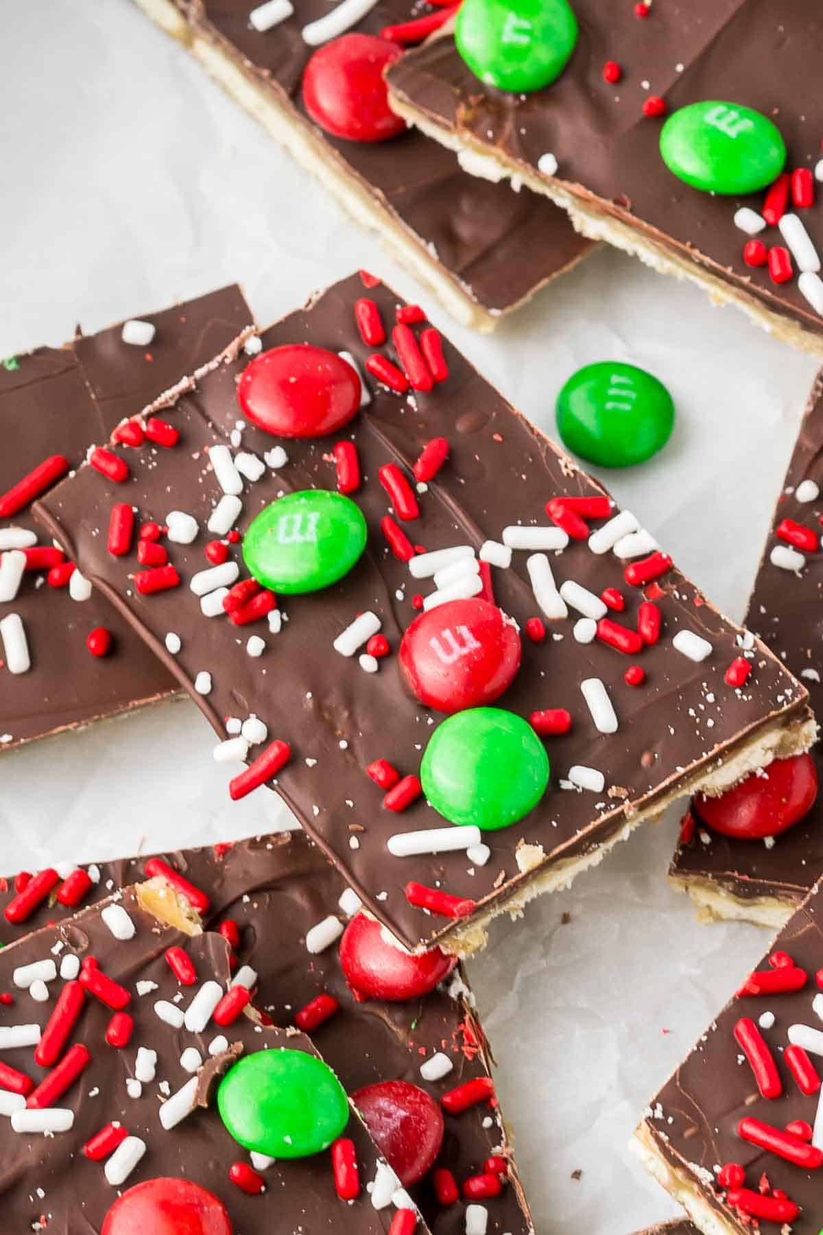 Saltine cracker toffee on parchment paper cut into pieces.