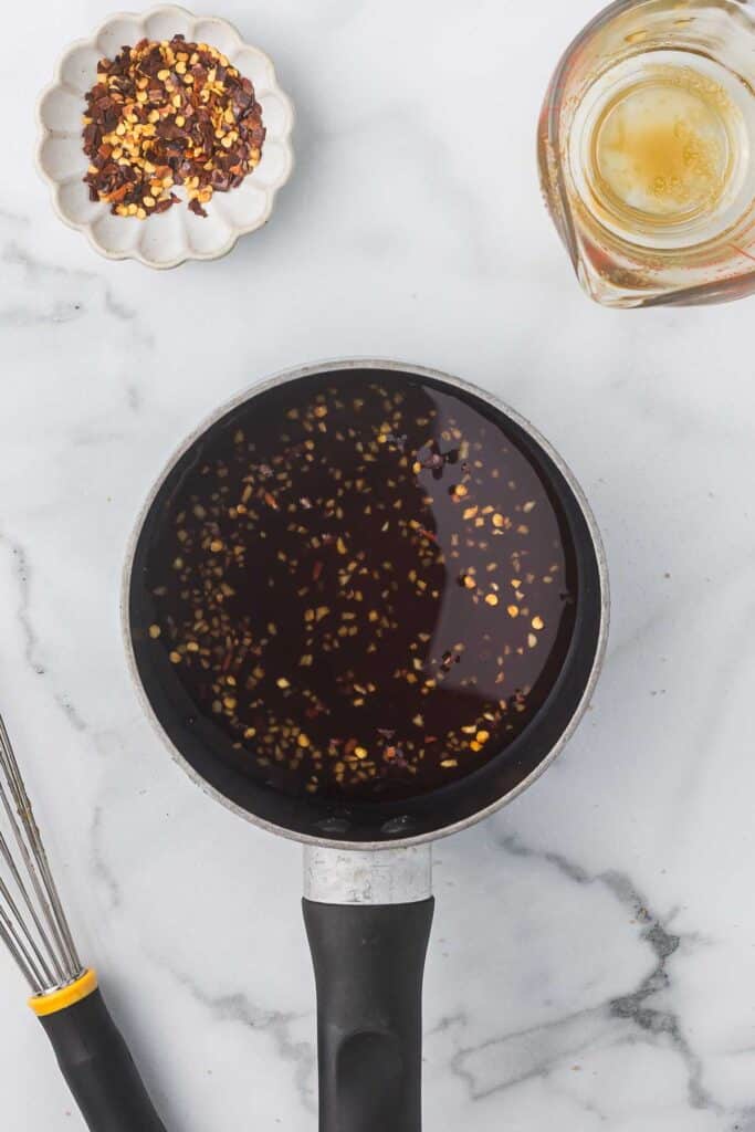 A sauce pan with ingredients to create a teriyaki sauce before cooking.