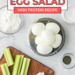 Ingredients for cottage cheese egg salad arranged on a marble surface, including hard-boiled eggs, cottage cheese, celery sticks, onion slices, relish, and seasoning. Text overlay reads 'Cottage Cheese Egg Salad: High Protein Recipe' and 'Full recipe @ cookingupmemories.com'.