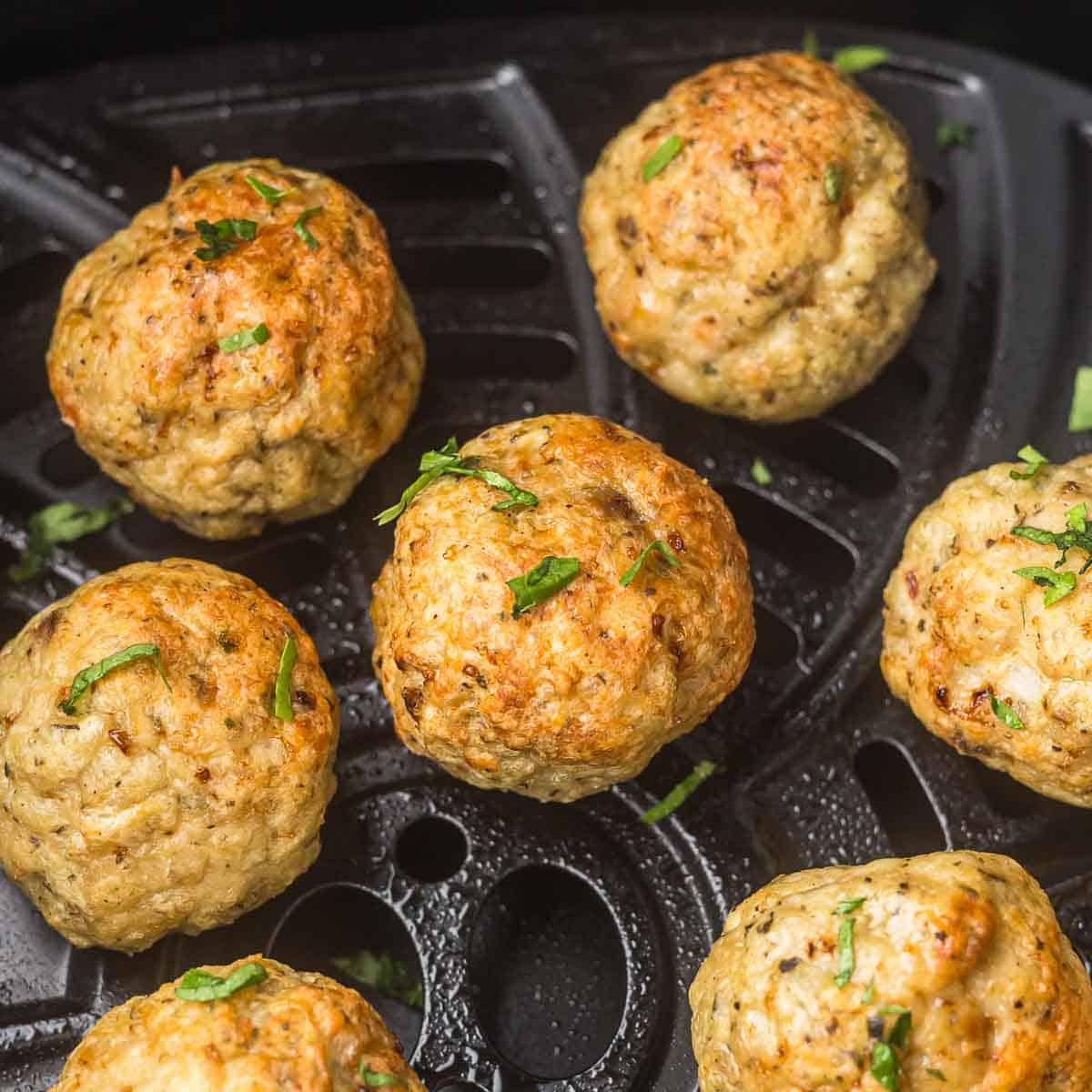 Chicken Meatballs that have been air fried in an air fryer basket.