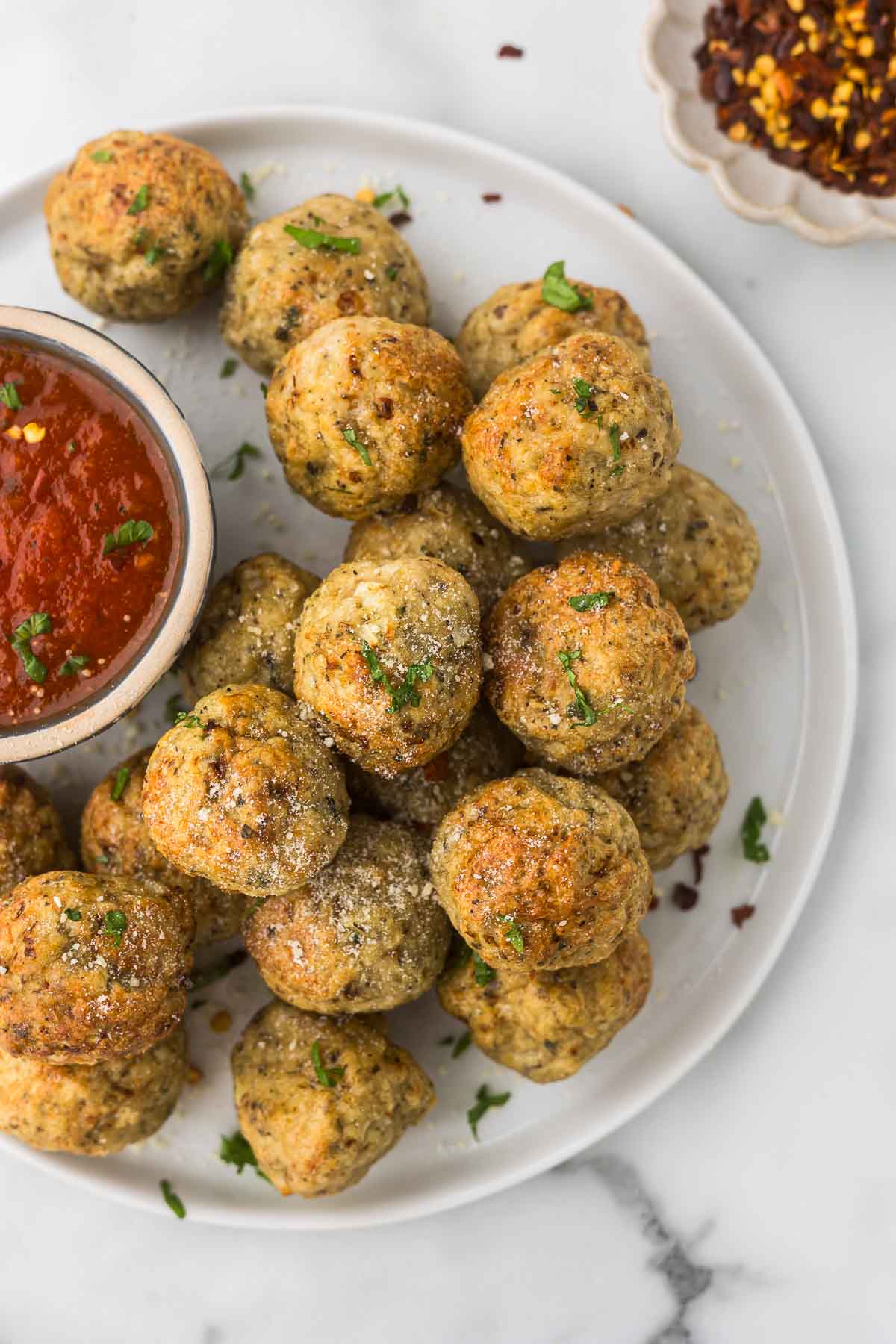 Chicken Meatballs air fryer on a plate with marinara for dipping. 