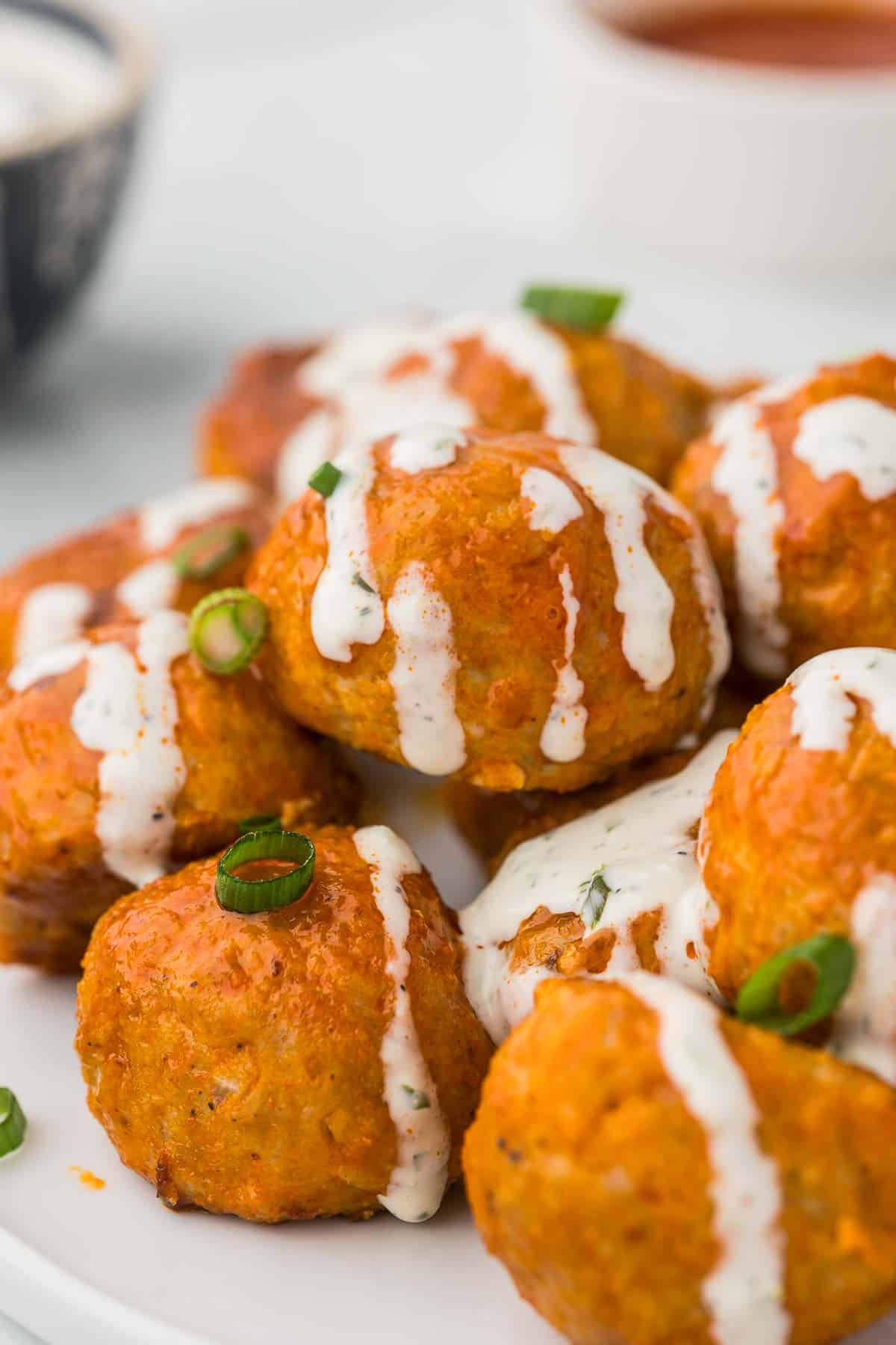 A pile of meatballs with buffalo sauce and ranch dressing.