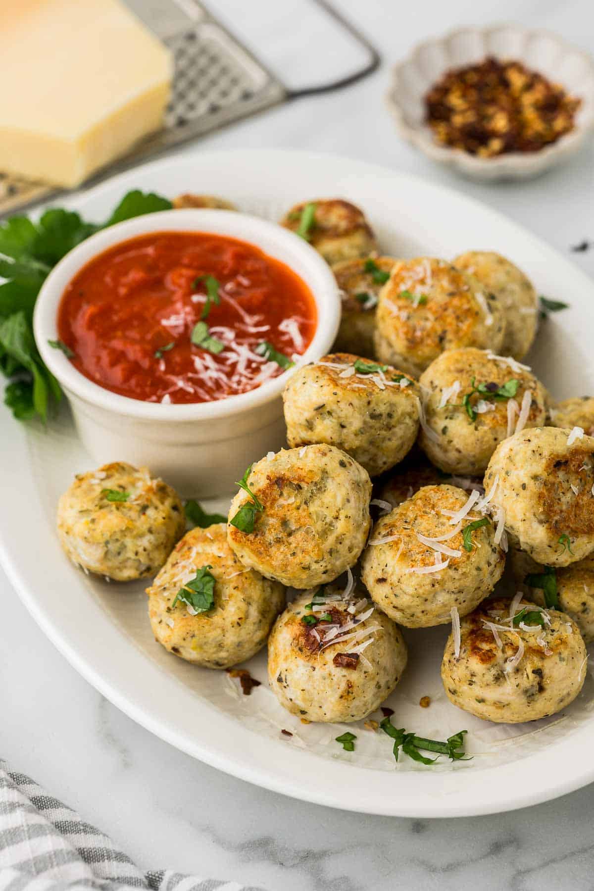 Chicken Meatballs made with Ricotta cheese on a platter and homemade marinara sauce.