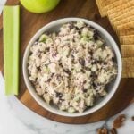 Tuna Salad with Cranberries and Apples in a bowl with crackers and celery.