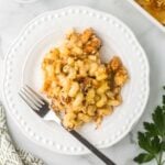 Mac and Cheese with BBQ Chicken on a white plate with a fork.