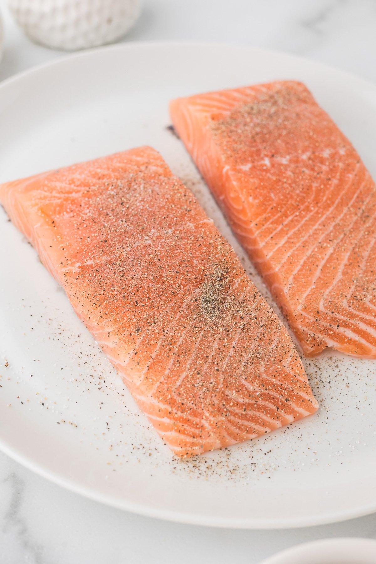 Salmon with salt and pepper sprinkled on both pieces.