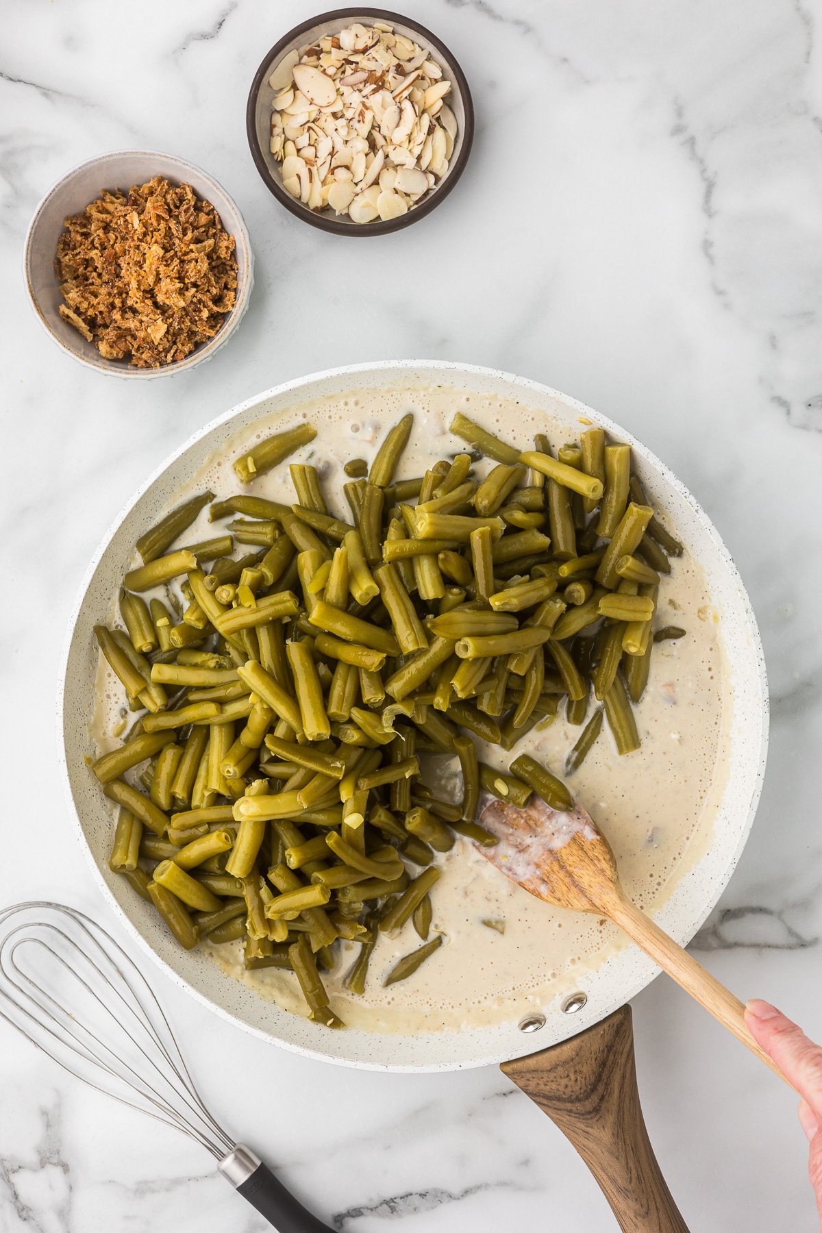 Green beans being added to the sauce for the green bean casserole.