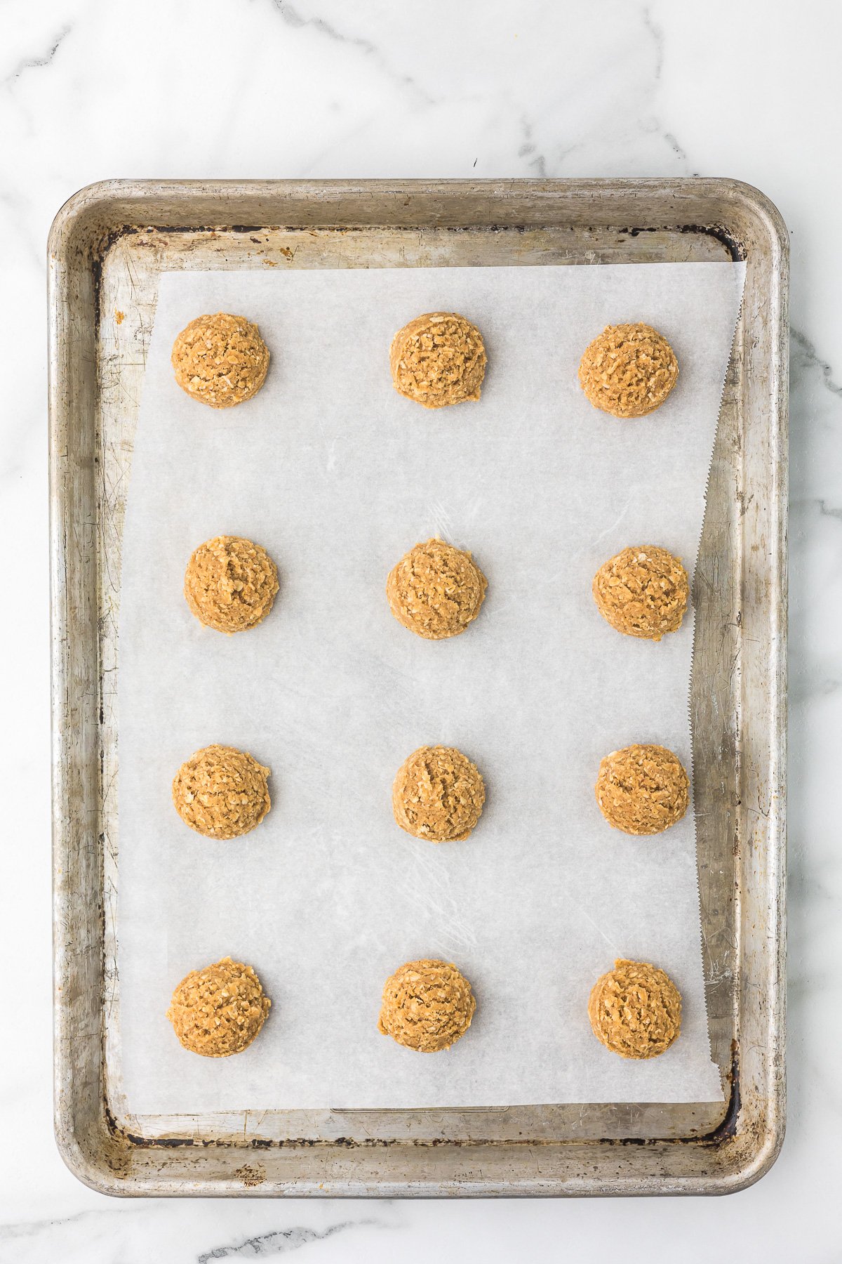 Two-Tablespoon dough scoops spaced on a parchment-lined sheet pan before chilling.
