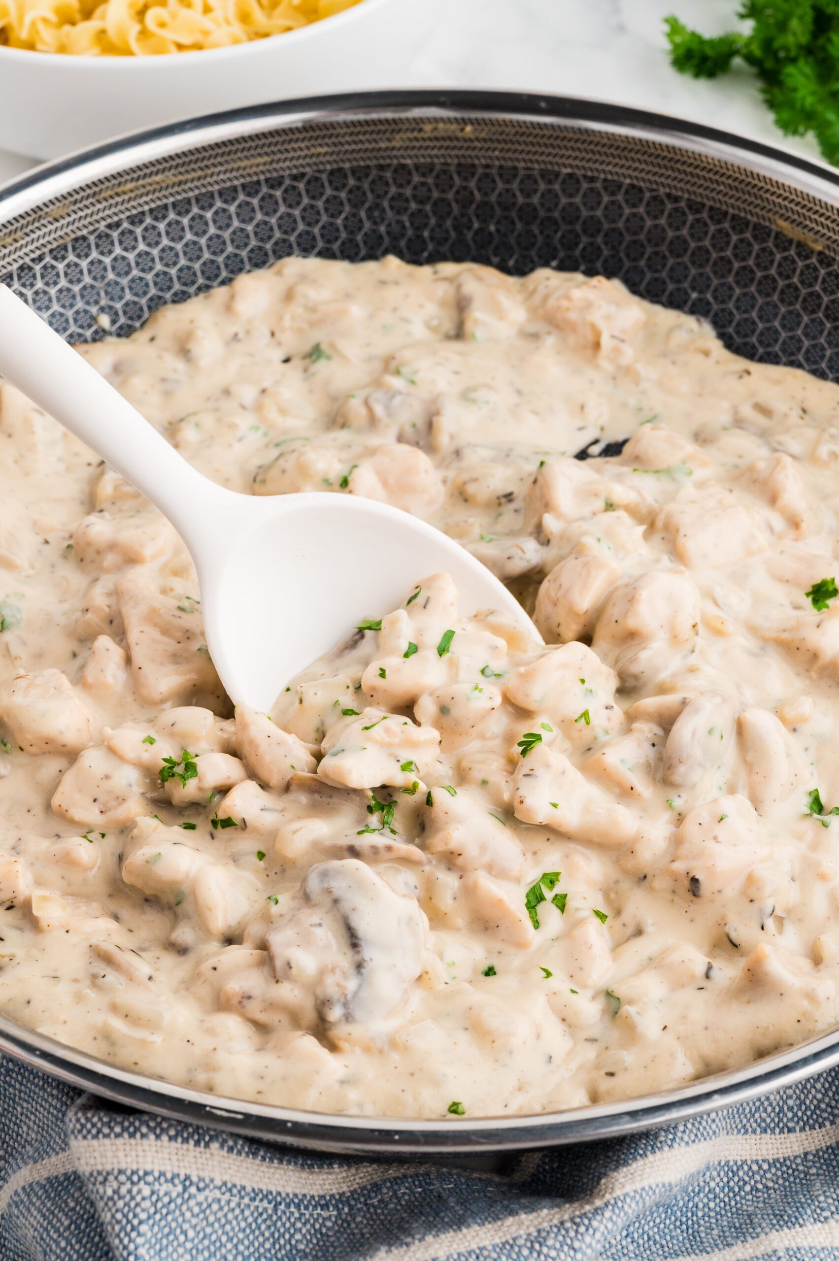 Chicken stroganoff in the pan with a spoon.