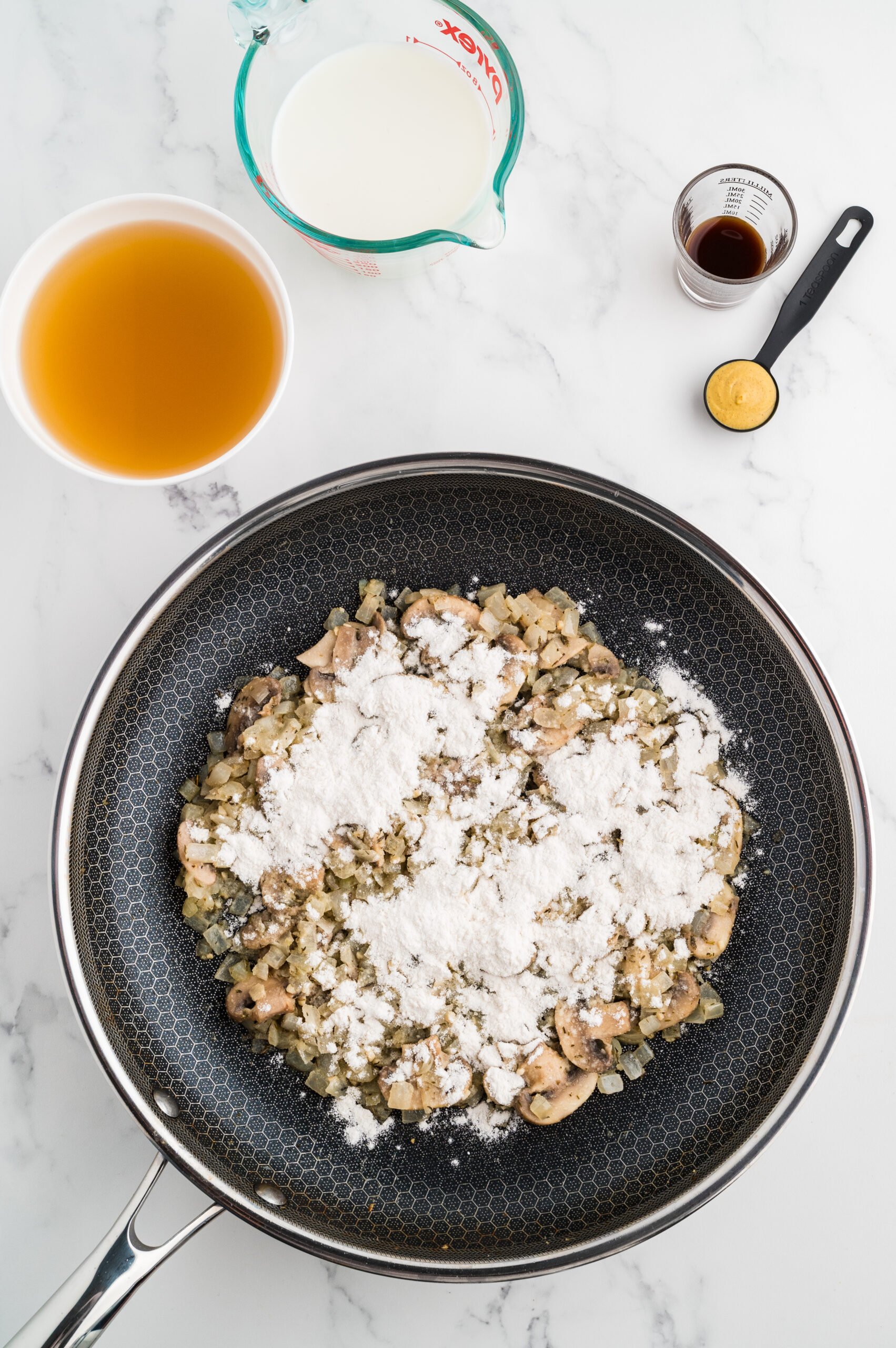 Vegetables with flour mixed in before adding broth to make a stroganoff homemade sauce.