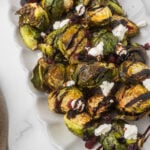 Air Fryer Brussels sprouts on a platter with balsamic, goat cheese and craisins.