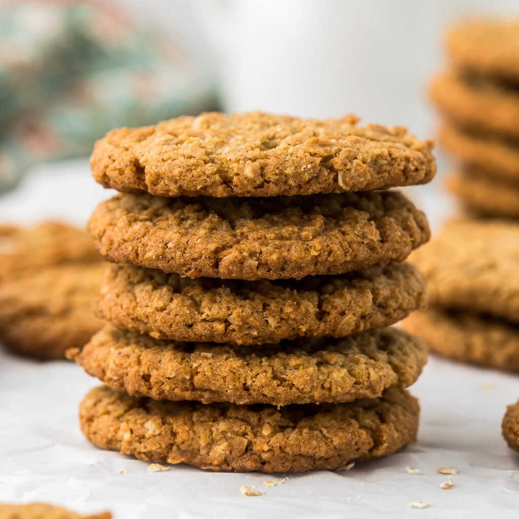 Brown Butter Oatmeal Cookies stacked on parchment paper.