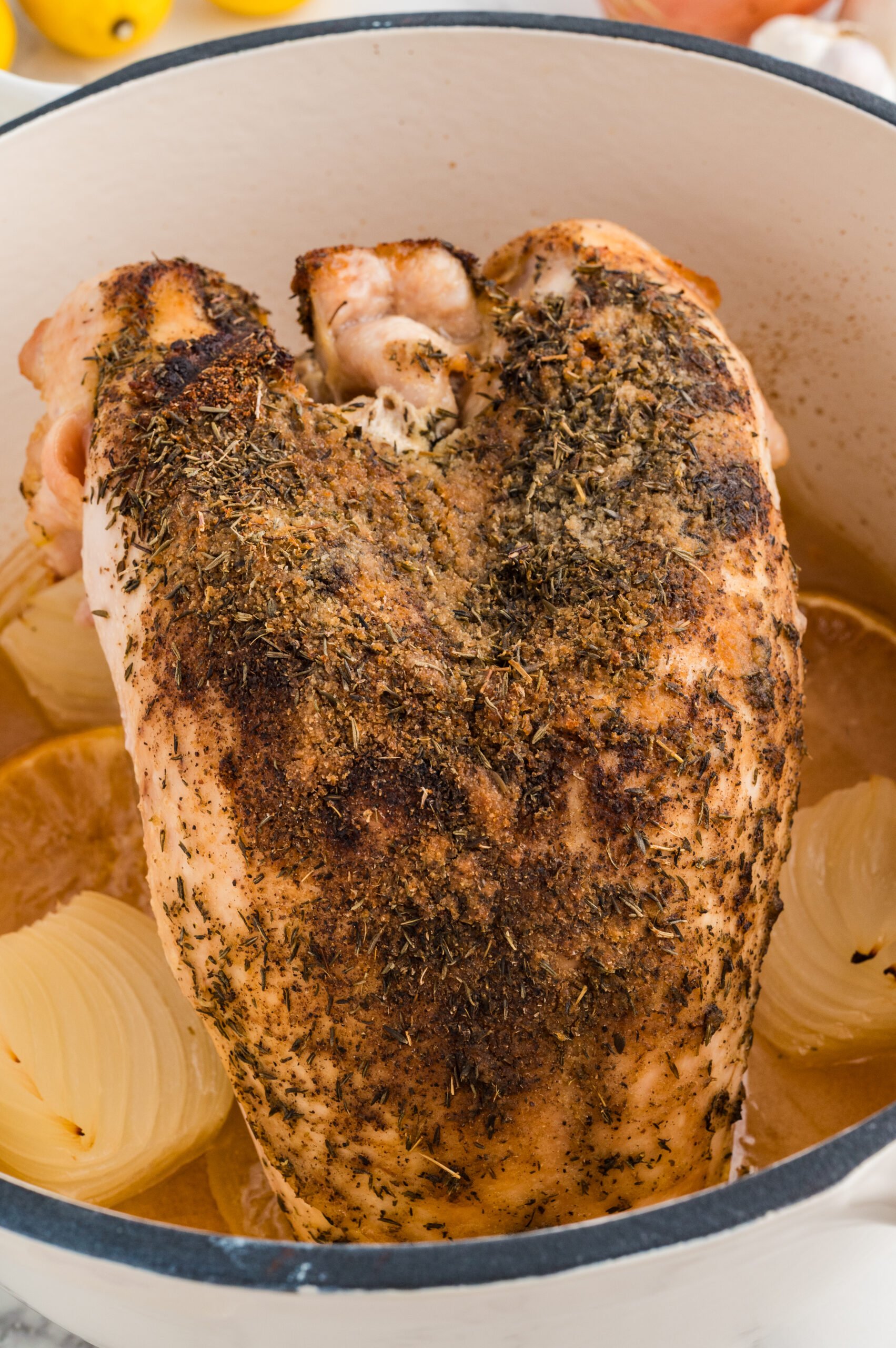Roasted turkey breast in a Dutch oven with golden skin and pan juices.