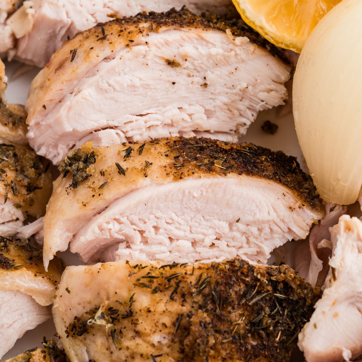 Juicy sliced turkey breast with crispy skin, lemon, and tender onion.