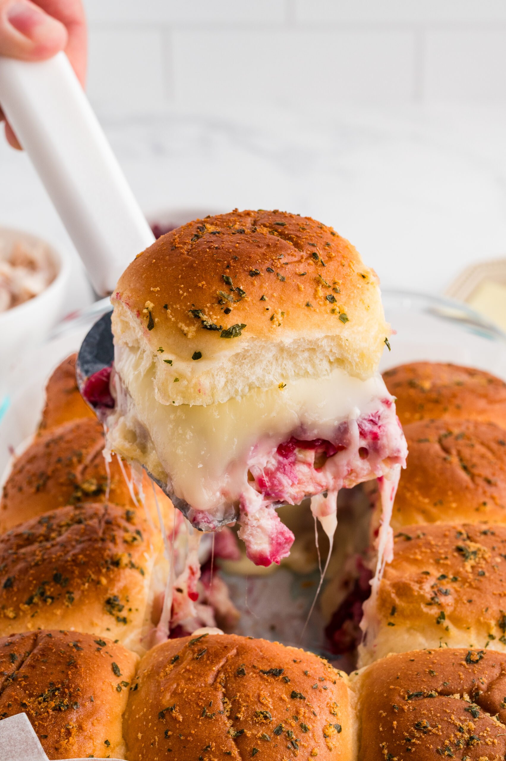 Slider being pulled out of a pan with a spatula.
