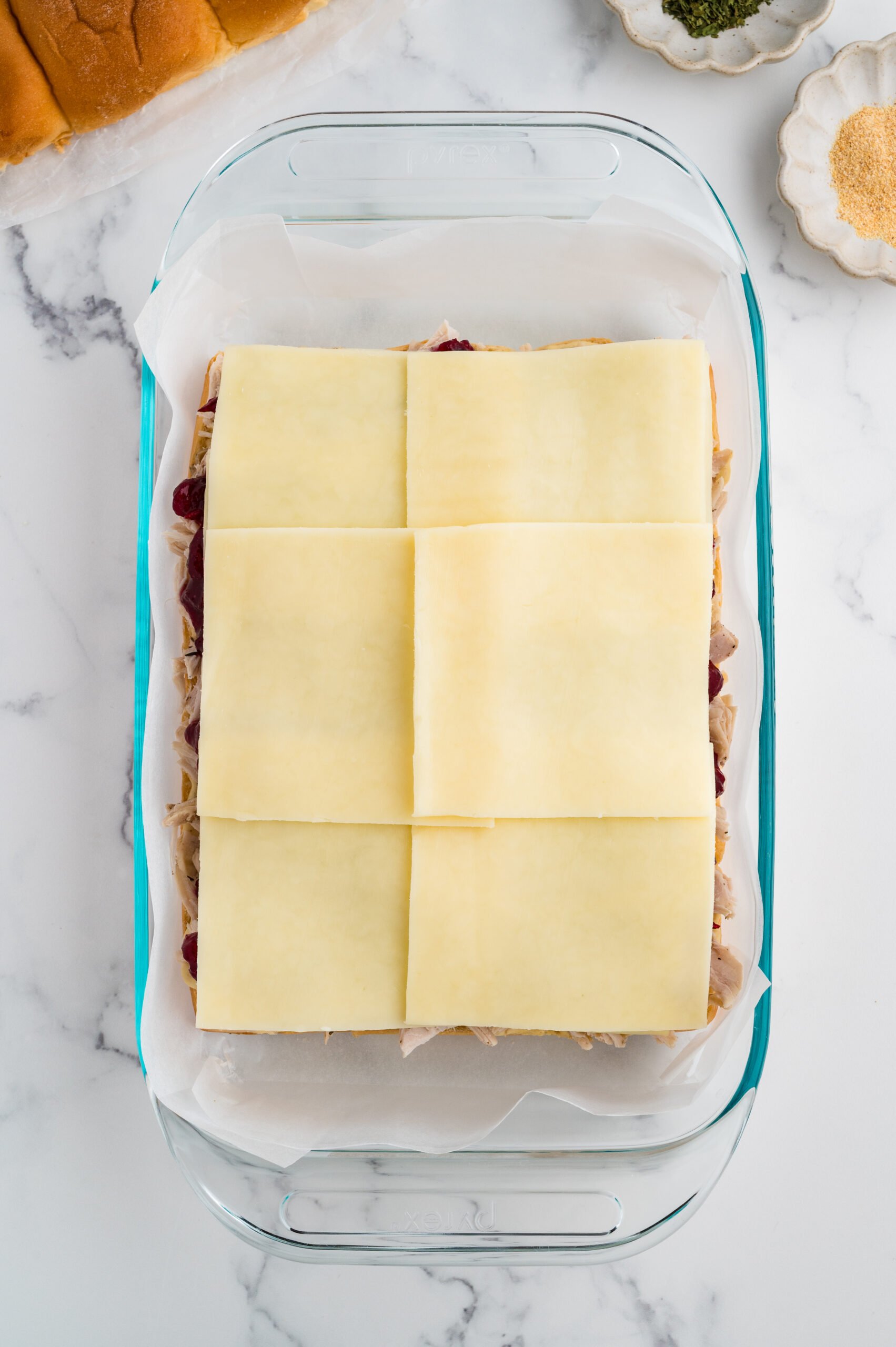 Slices of cheese arranged across the cranberry layer, covering the entire surface.