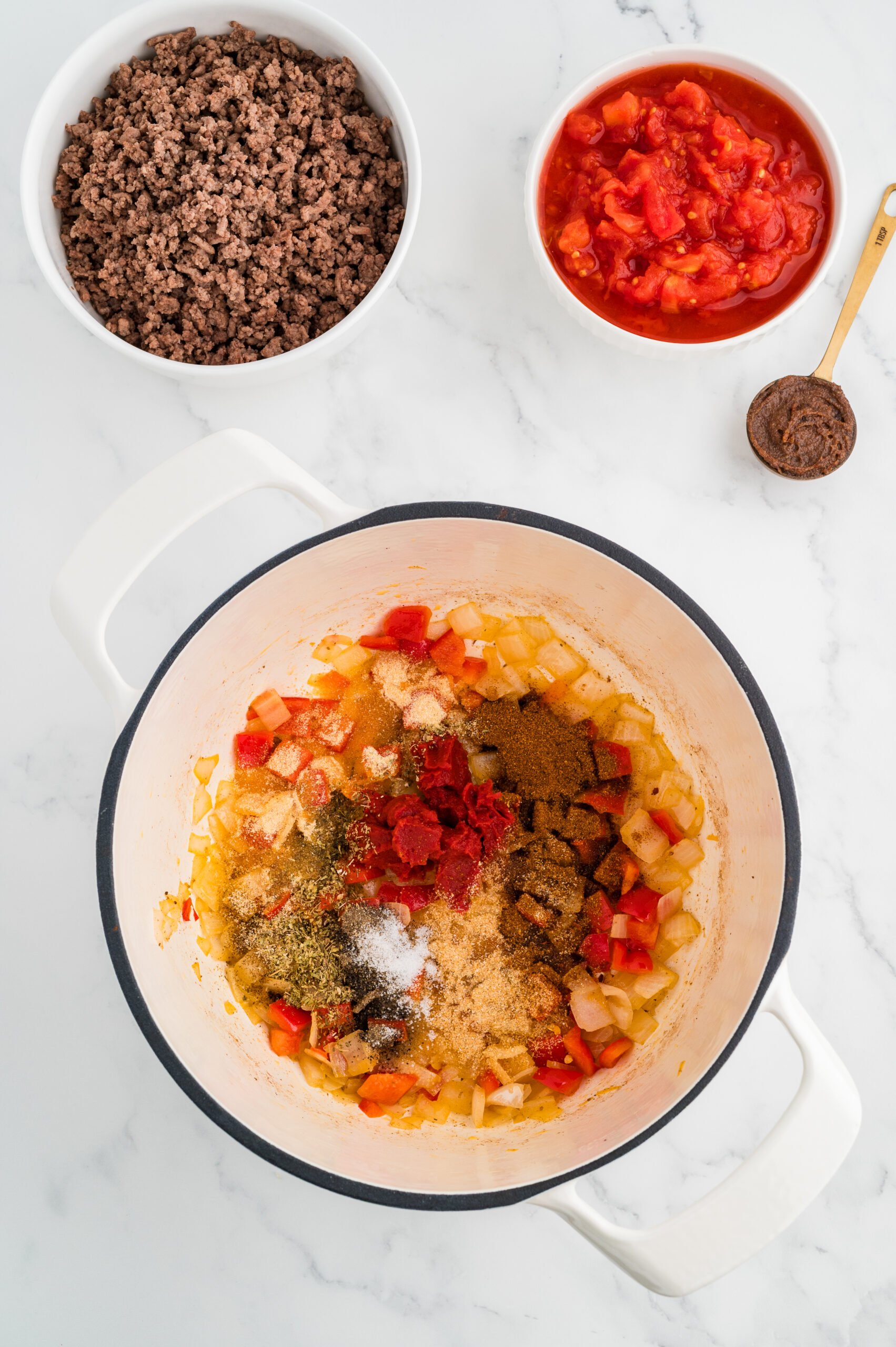 Tomato paste and spices added to sautéed vegetables for cabbage roll soup.