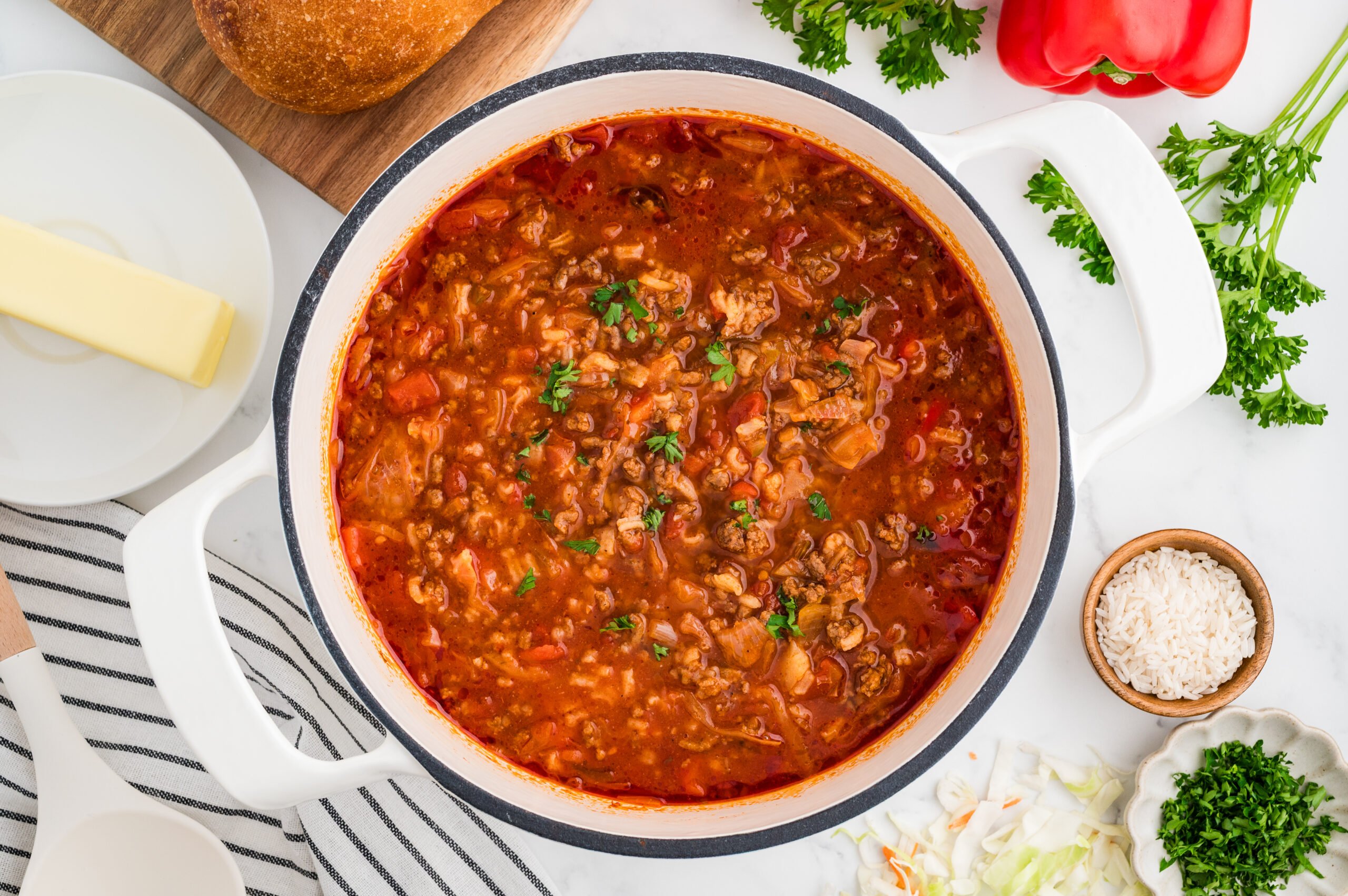 Cabbage Rolls Soup in a dutch oven with salt and parsley around the pot.