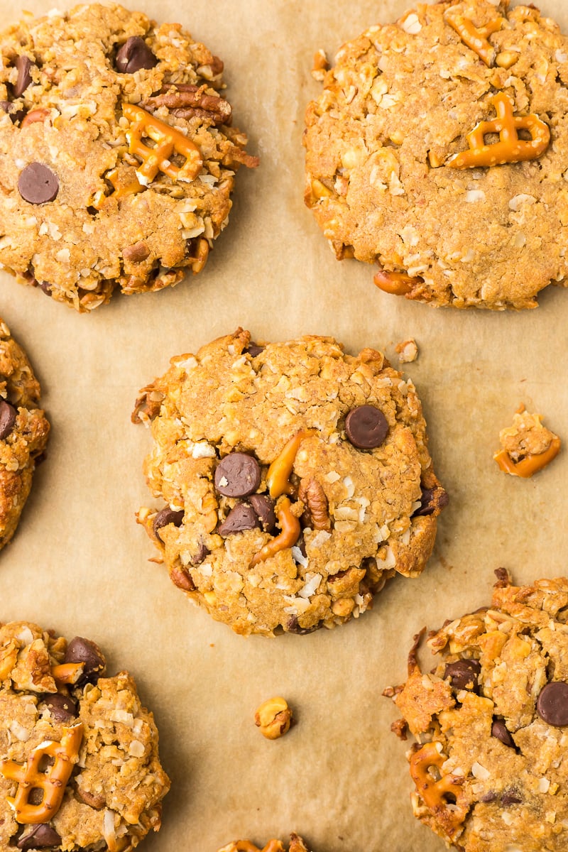 Baked peanut butter breakfast cookies with oats, chocolate chips, pretzels, and pecans on a parchment-lined baking sheet.