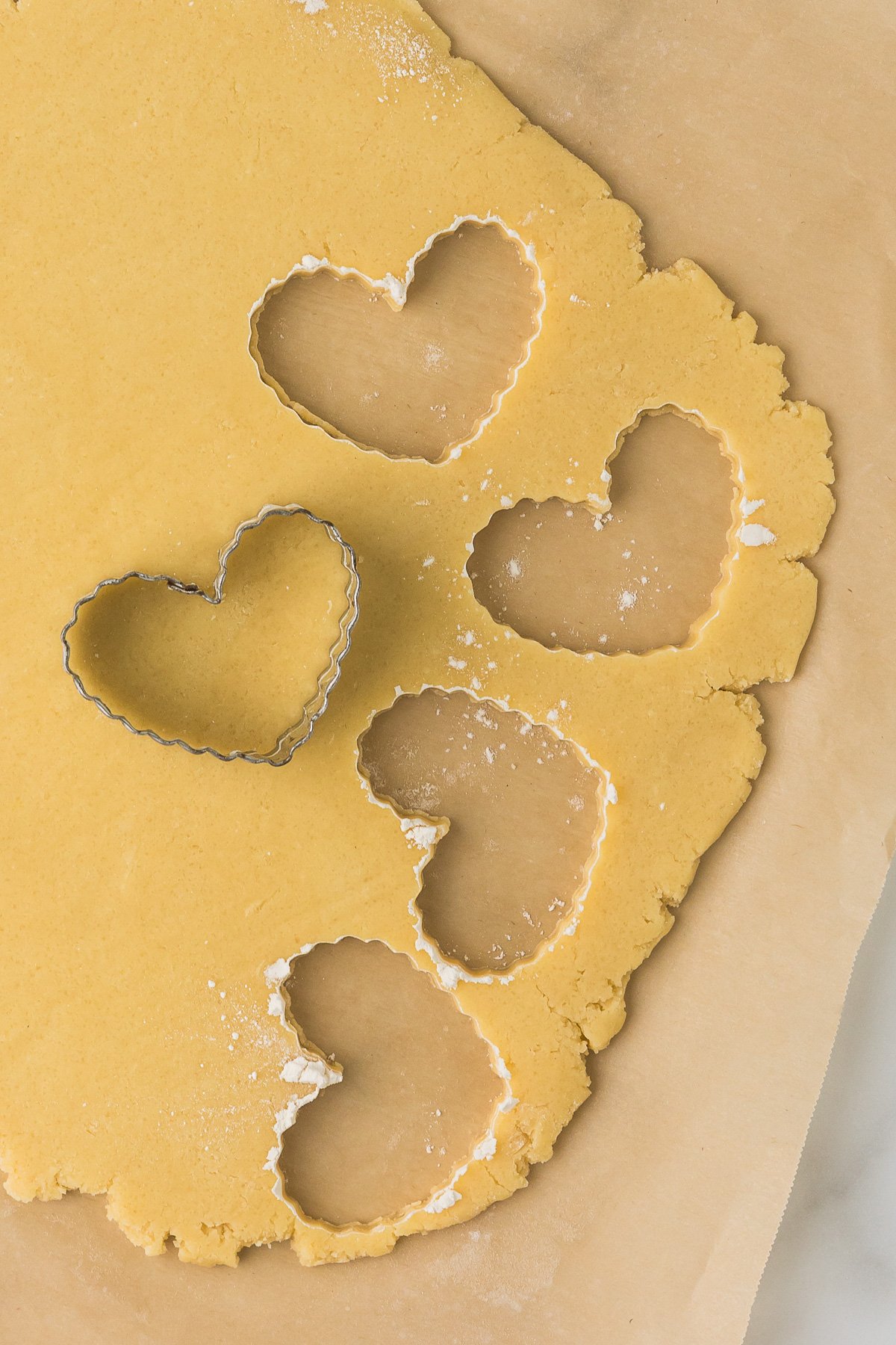 Cutting chilled dough with cookie cutters for clean cut out sugar cookies.