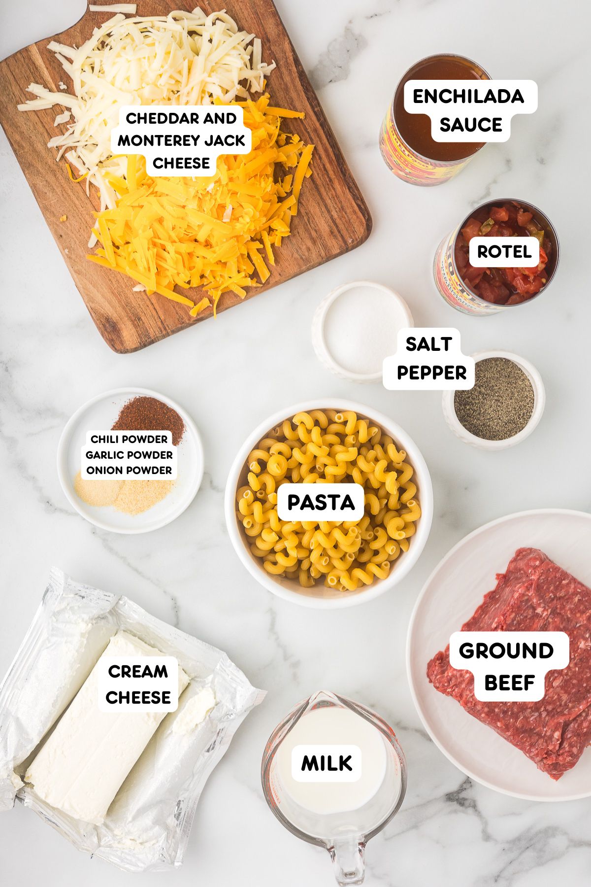 Ingredients for Mexican mac and cheese including ground beef, pasta, enchilada sauce, Rotel, cream cheese, milk, and shredded cheese.