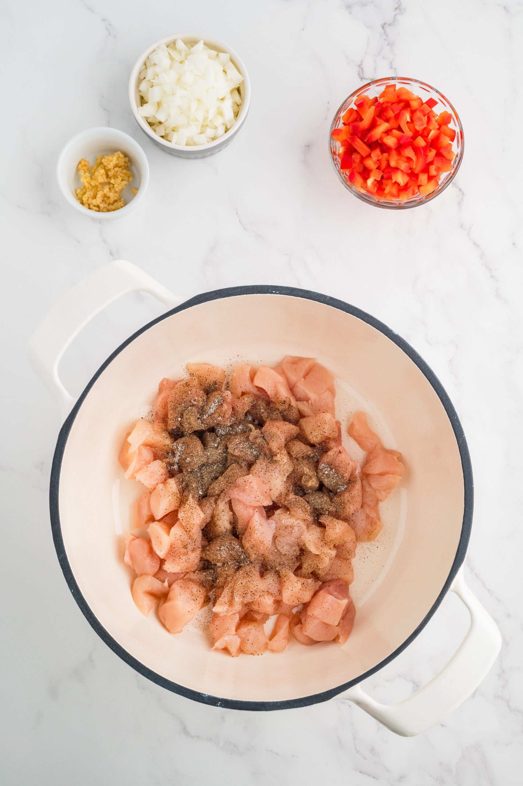 Diced chicken seasoned with salt and pepper in a pot for taco chicken soup.
