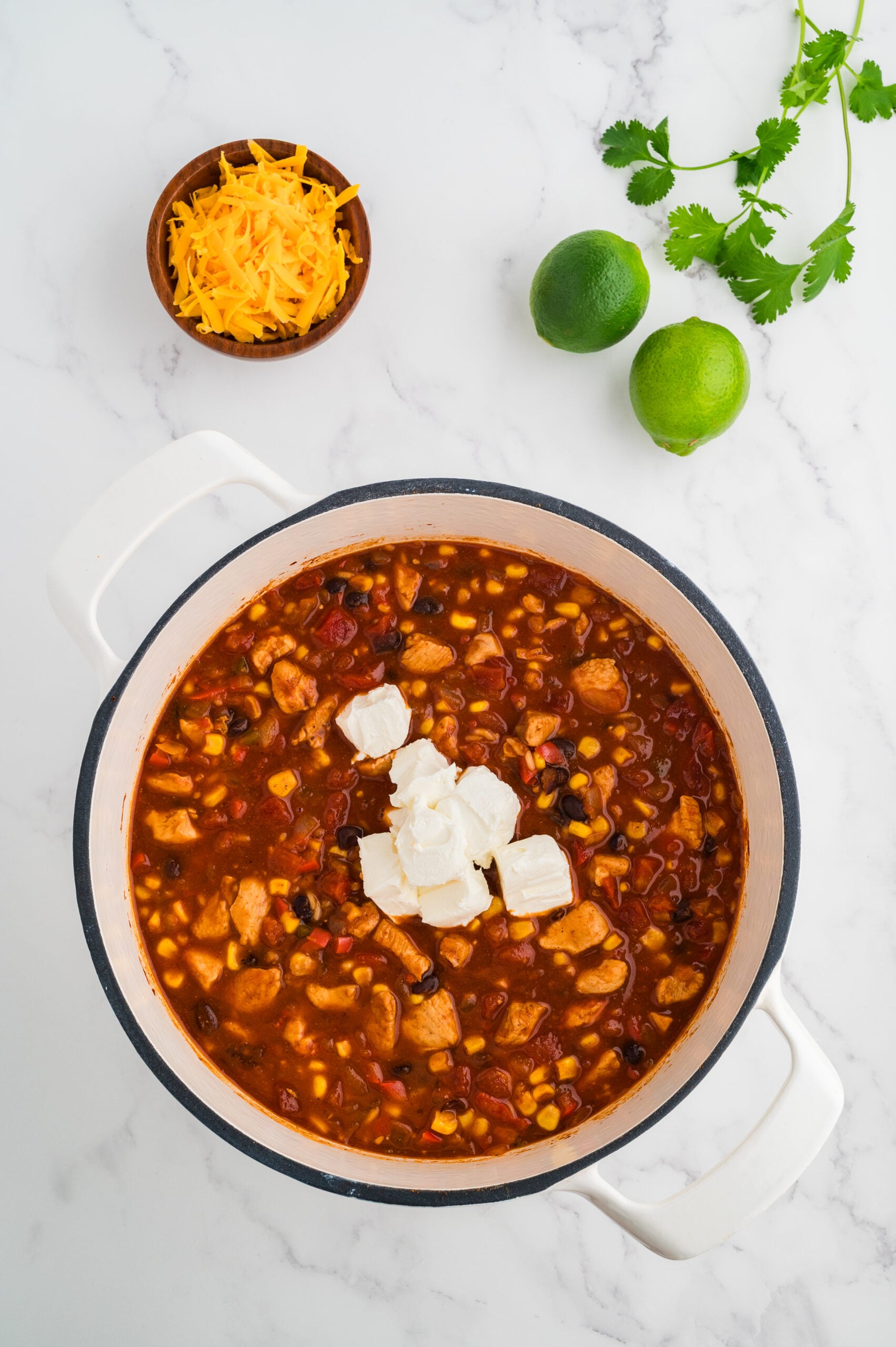 Cubed cream cheese added to taco chicken soup for a creamy finish.