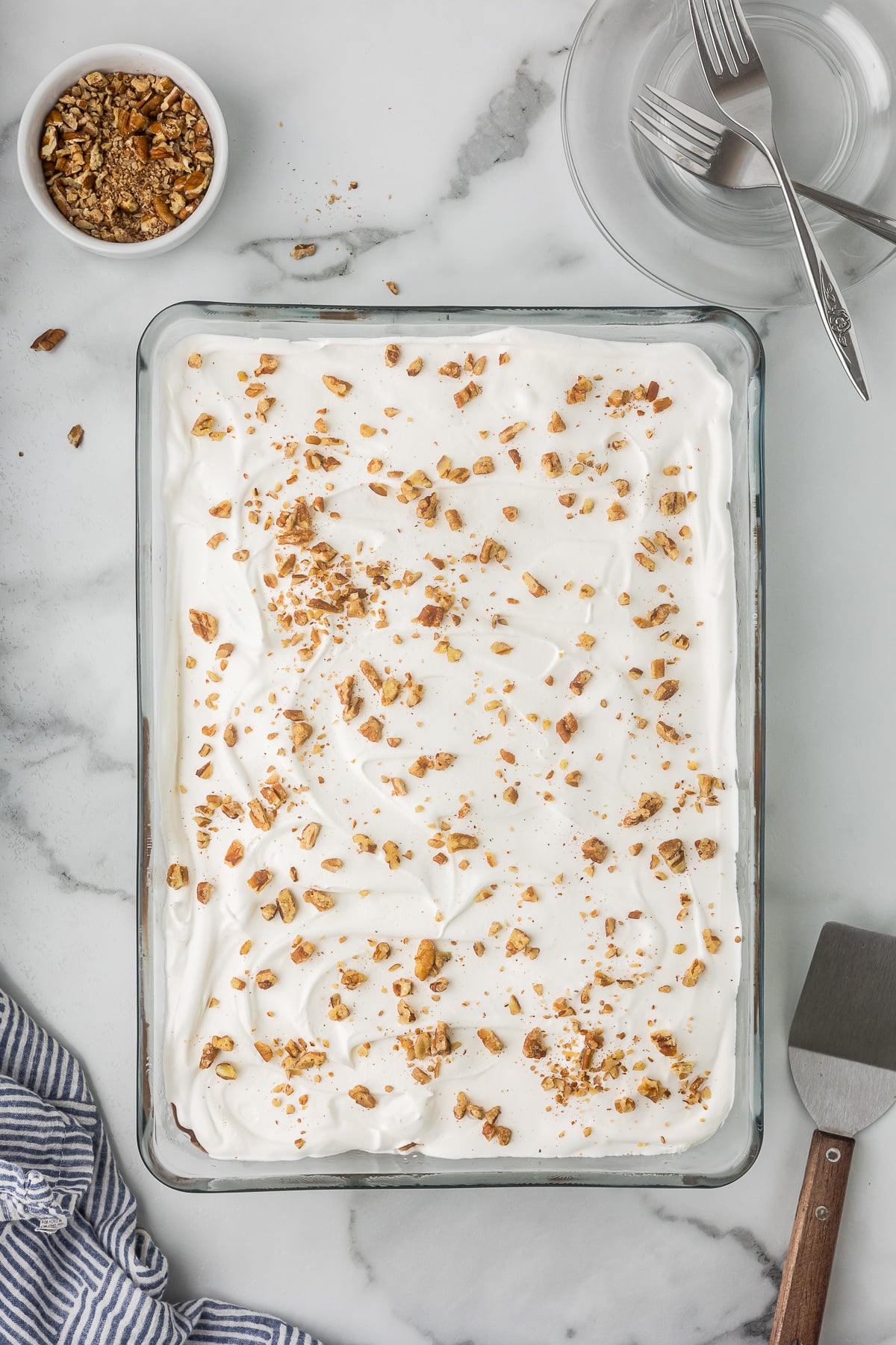 Chocolate Delight topped with whipped topping and chopped pecans before chilling.