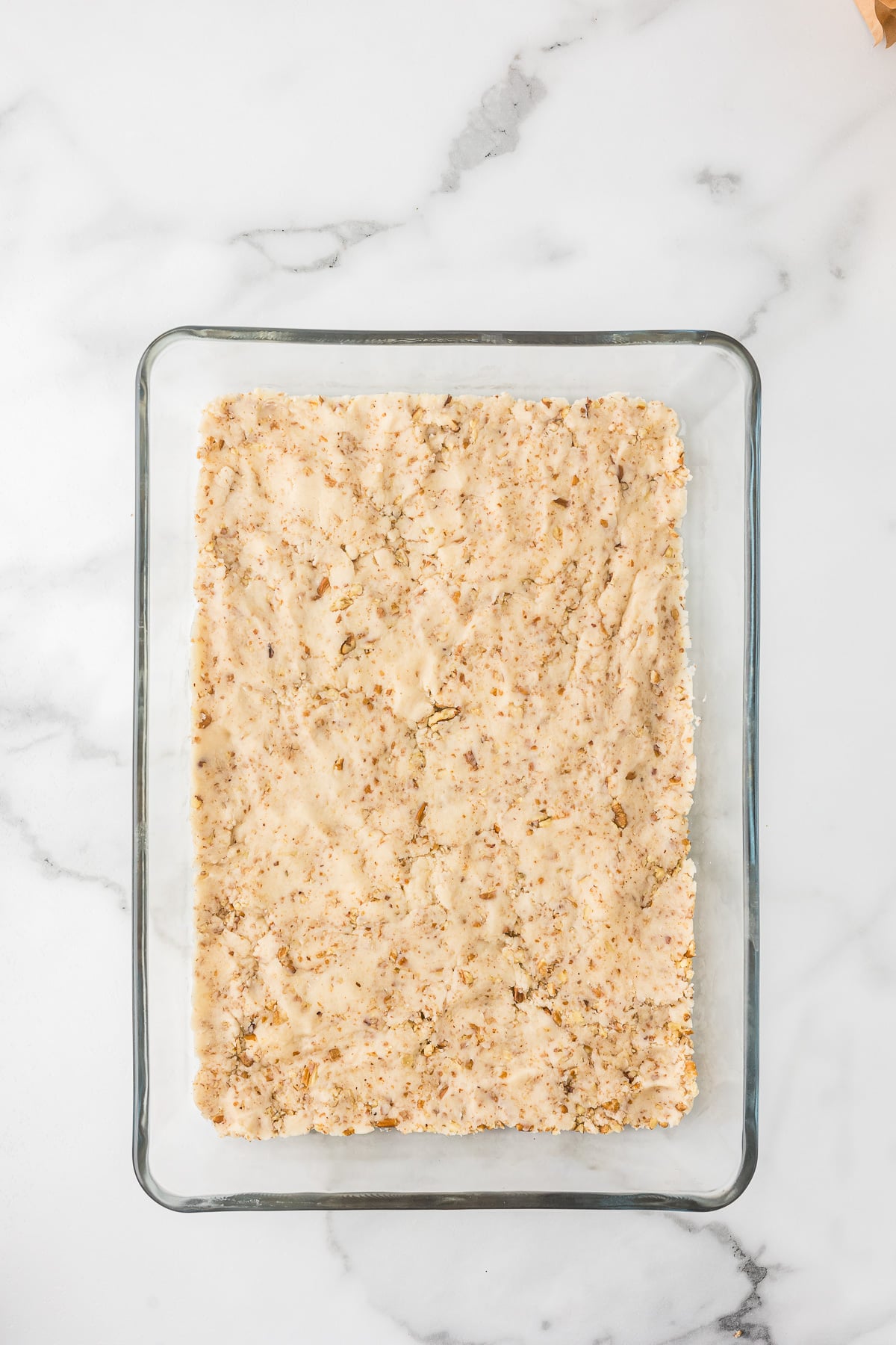 Pecan crust pressed into a 9x13 glass baking dish for Chocolate Delight.